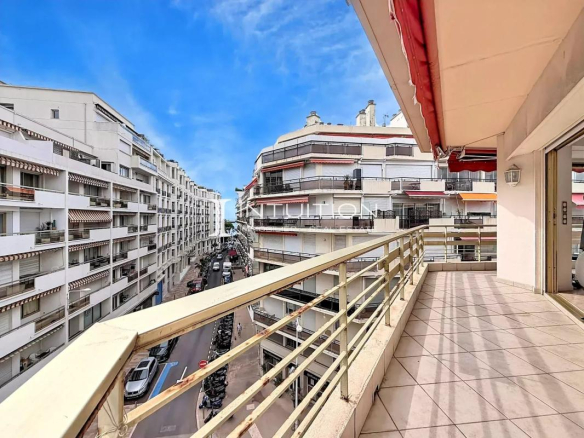 View from the terrace of an apartment in Cannes, with a glimpse of the sea and surrounding buildings.