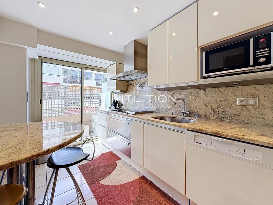 Apartment kitchen in Cannes Modern kitchen in a Cannes apartment with bar and built-in appliances.