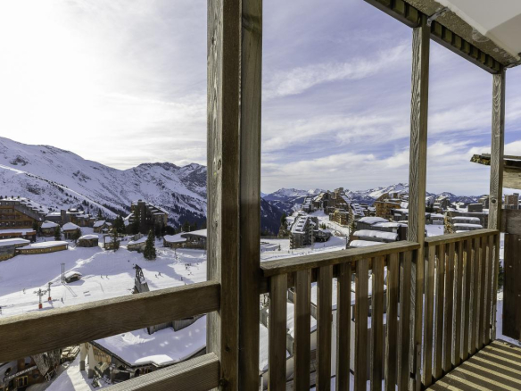 Vue panoramique depuis un balcon sur les montagnes enneigées et la station d'Avoriaz.