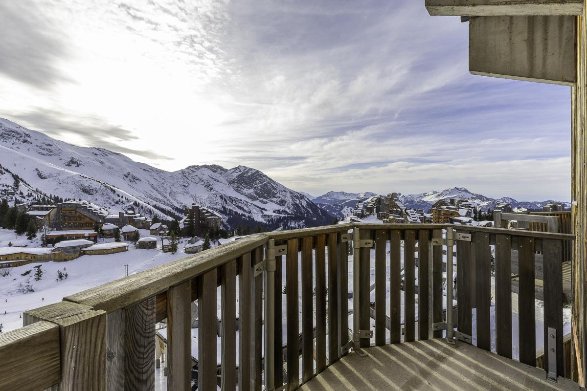 Vue panoramique depuis le balcon d'un penthouse à Avoriaz, avec montagnes enneigées en arrière-plan.