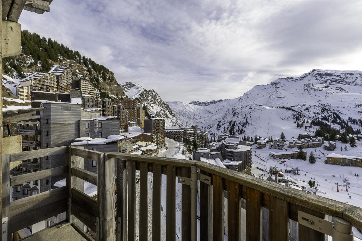 Vue panoramique depuis un balcon d'un penthouse à Avoriaz, avec des montagnes enneigées en arrière-plan.