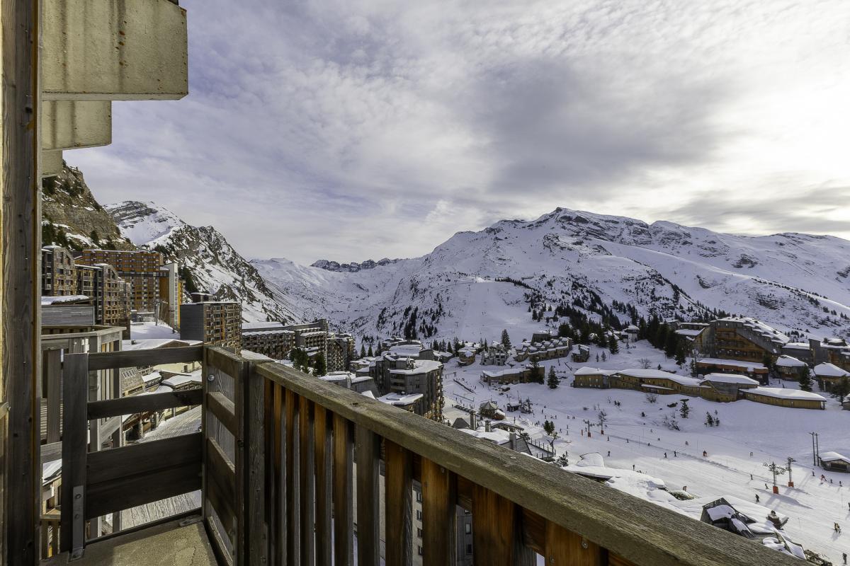 Vue panoramique depuis un balcon d'un penthouse à Avoriaz, avec des montagnes enneigées en arrière-plan.