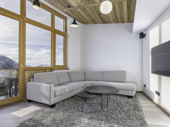 Intérieur d'un penthouse duplex à Avoriaz avec un salon moderne et vue sur les montagnes.
