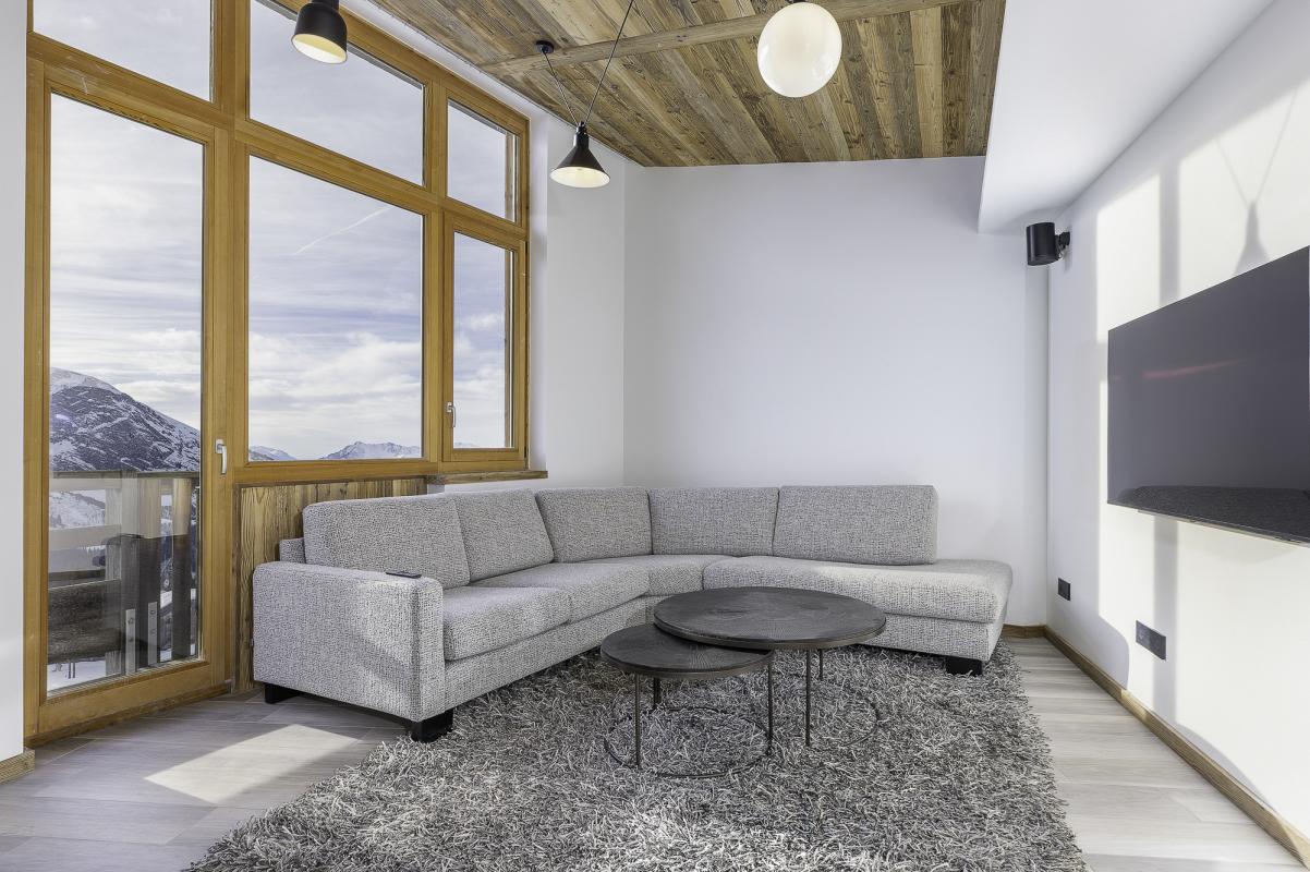 Intérieur d'un penthouse duplex à Avoriaz avec un salon moderne et vue sur les montagnes.