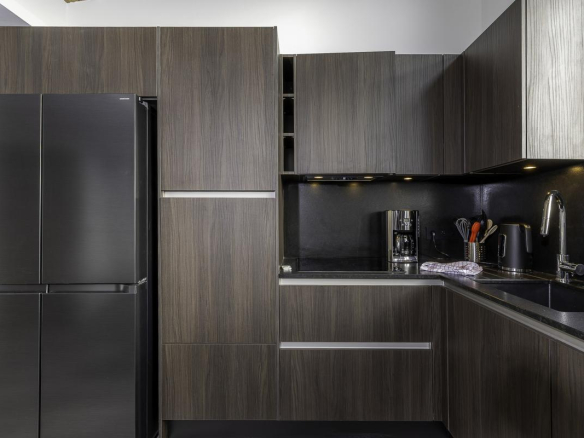 Cuisine moderne et spacieuse d'un penthouse à Avoriaz, avec des meubles en bois foncé et des équipements haut de gamme.