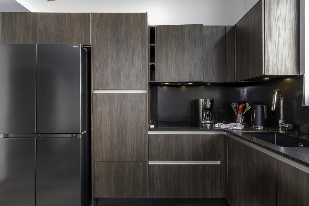 Cuisine moderne et spacieuse d'un penthouse à Avoriaz, avec des meubles en bois foncé et des équipements haut de gamme.