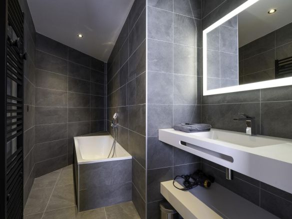 Salle de bain moderne avec baignoire et miroir lumineux dans un penthouse à Avoriaz.
