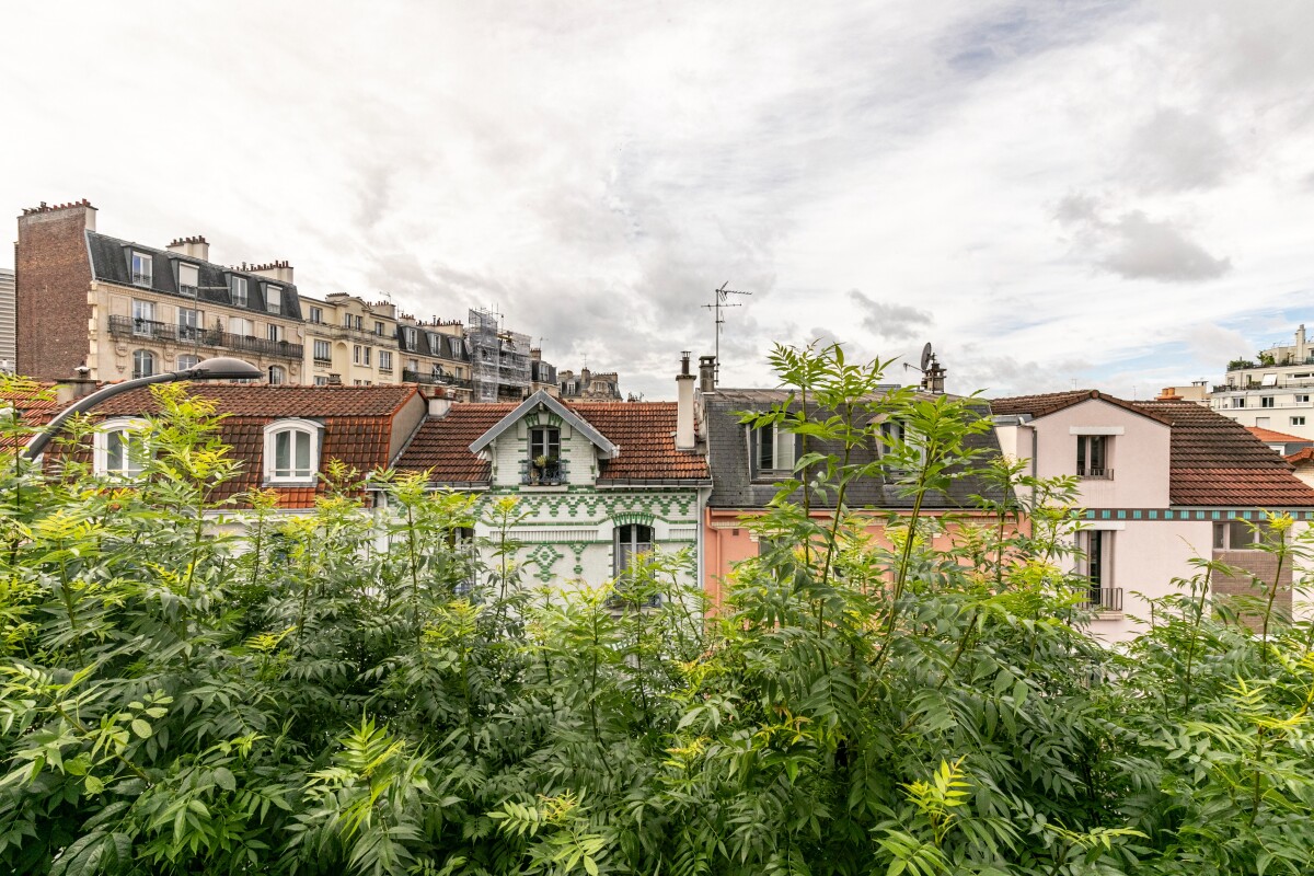 Houses in Paris 13th View of traditional houses in Paris, partially hidden by foliage.