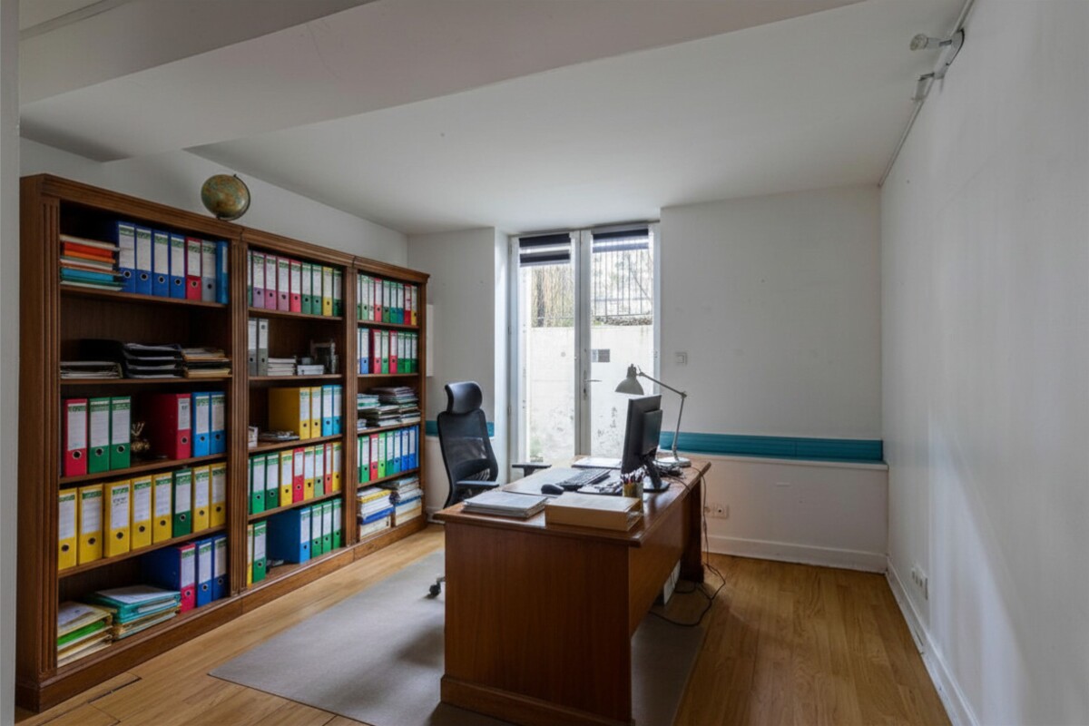Office in a house in Paris Office with a bookcase and a wooden desk, windows overlooking the outside.