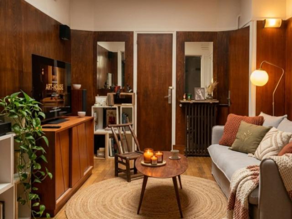Interior of a house in Paris with a cozy living room, sofa, coffee table and television.