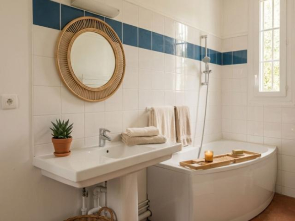 Modern bathroom with bathtub, sink and mirror, decorated with white and blue tiles.