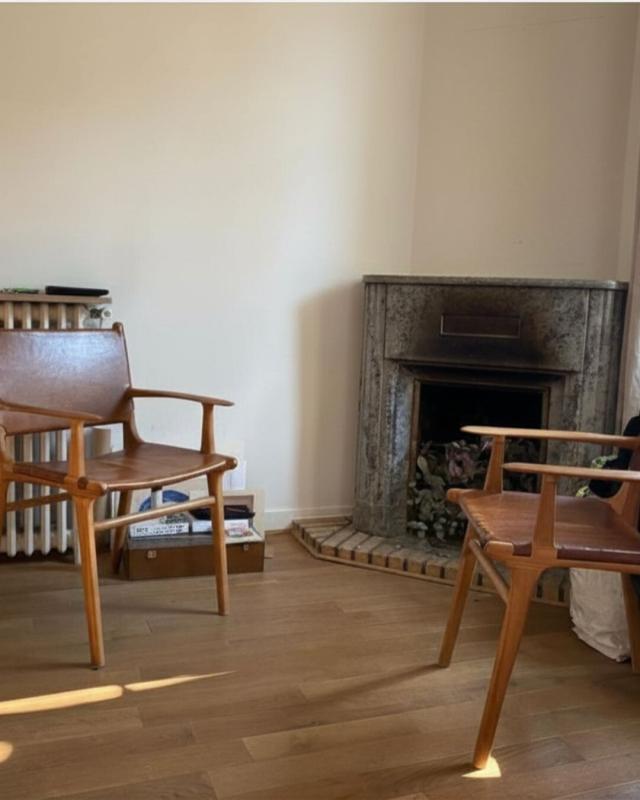 Interior of a house in Paris Interior of a house with two wooden chairs and a marble fireplace.