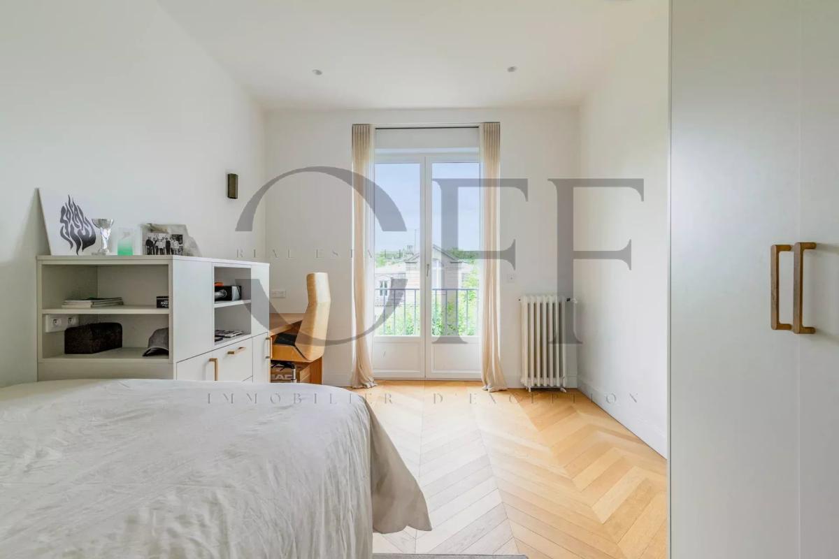 Bedroom in a penthouse in Neuilly-sur-Seine Bright bedroom in a penthouse in Neuilly-sur-Seine, with wooden parquet flooring and a view of the outside.