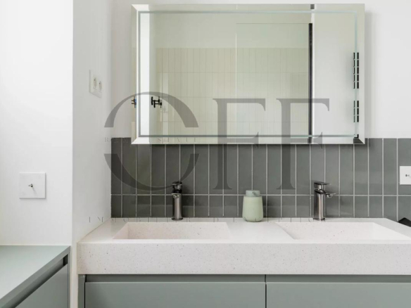 Modern bathroom with double sink and mirror, grey and white walls.