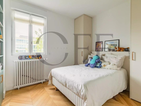 Bedroom in a duplex penthouse in Neuilly-sur-Seine with bed and shelves.
