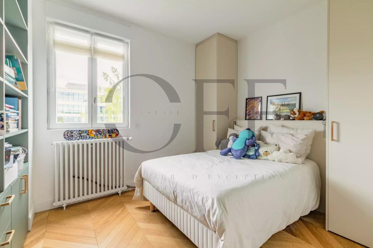 Penthouse bedroom in Neuilly-sur-Seine Bedroom in a duplex penthouse in Neuilly-sur-Seine with bed and shelves.