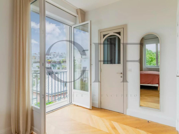 Interior of a penthouse in Neuilly-sur-Seine with open windows and wooden parquet flooring.