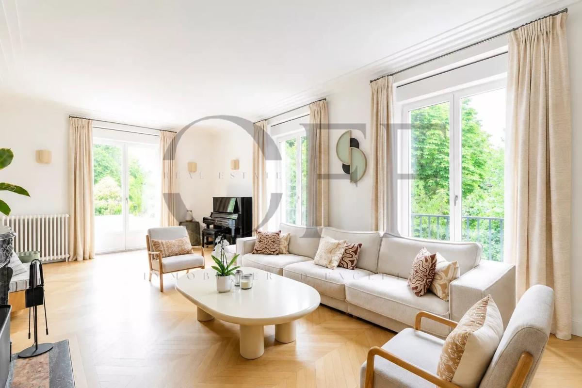 Duplex penthouse in Neuilly-sur-Seine Interior of a duplex penthouse in Neuilly-sur-Seine with a bright living room and windows overlooking a garden.