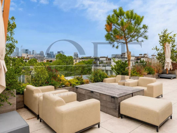 Landscaped terrace of a penthouse in Neuilly-sur-Seine with modern furniture and city view.