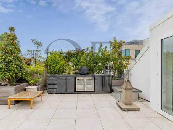 Landscaped terrace of a duplex penthouse in Neuilly-sur-Seine with modern furniture and unobstructed view.