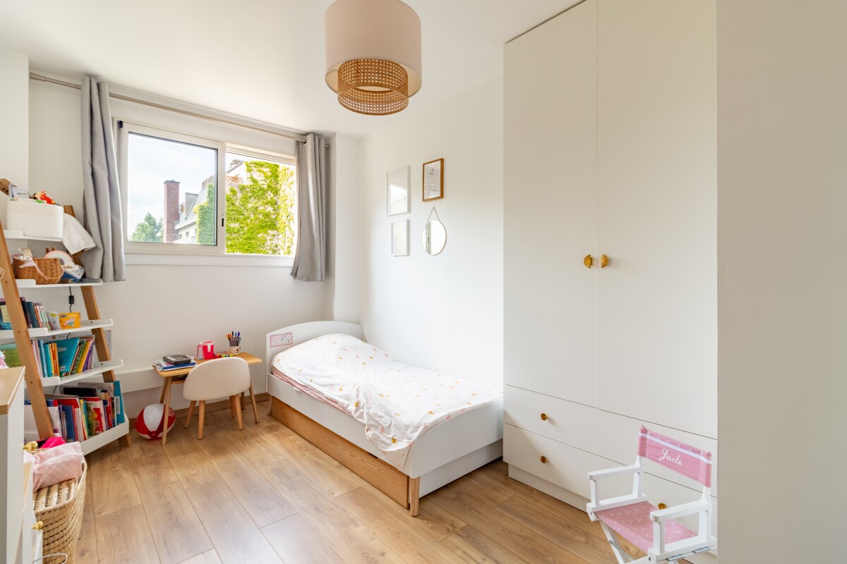 Chambre d’appartement à Paris Chambre d'un appartement à Paris avec lit simple et étagère.