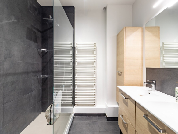 Salle de bain moderne avec douche à l'italienne et meuble vasque en bois.