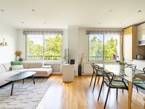 Intérieur d'un appartement de 82m² à Paris, salon lumineux avec canapé et table à manger.