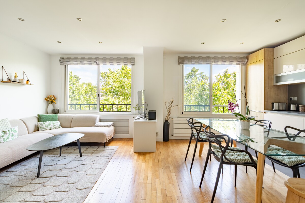 Appartement lumineux à Paris Intérieur d'un appartement de 82m² à Paris, salon lumineux avec canapé et table à manger.
