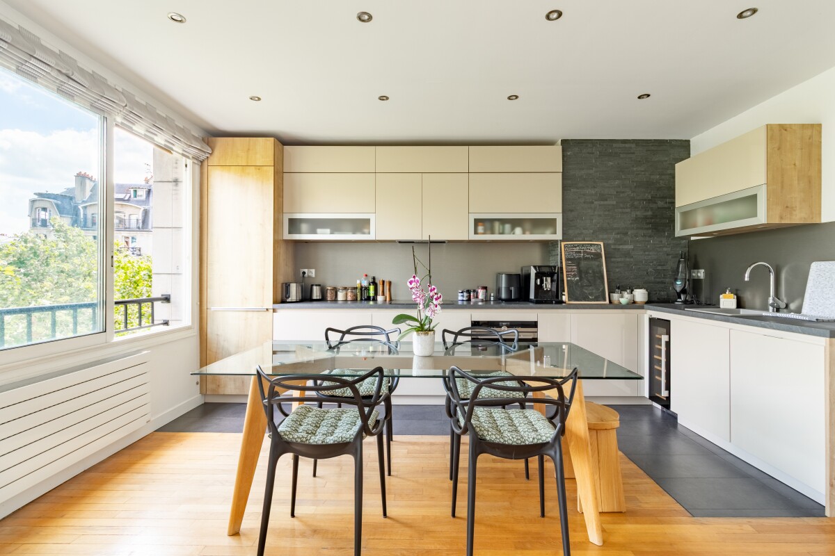 Cuisine et salle à manger d’un appartement à Paris Cuisine moderne avec salle à manger dans un appartement à Paris, fenêtres donnant sur l'extérieur.