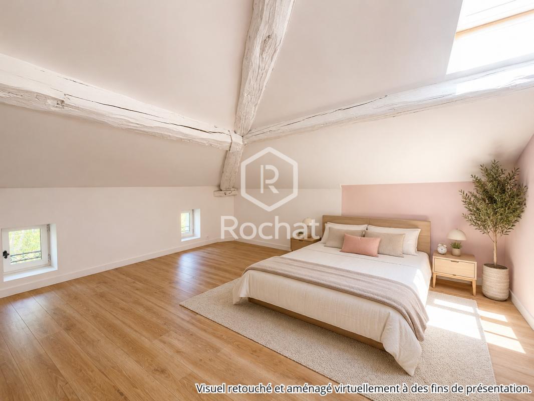 Chambre rénovée dans une maison à Curis-au-Mont-d’Or Chambre spacieuse avec poutres apparentes et parquet, lumière naturelle, maison à Curis-au-Mont-d'Or.