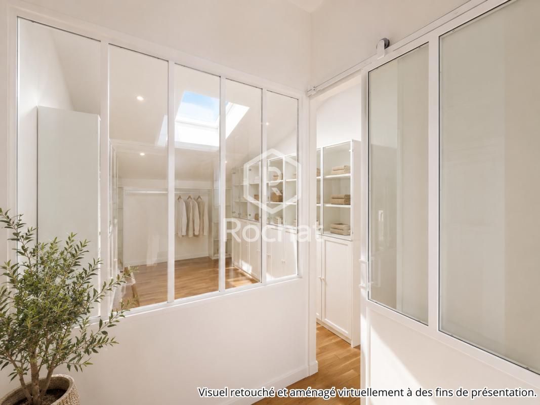 Intérieur d’une maison rénovée à Curis-au-Mont-d’Or Intérieur d'une maison rénovée avec des murs en verre et un éclairage naturel.