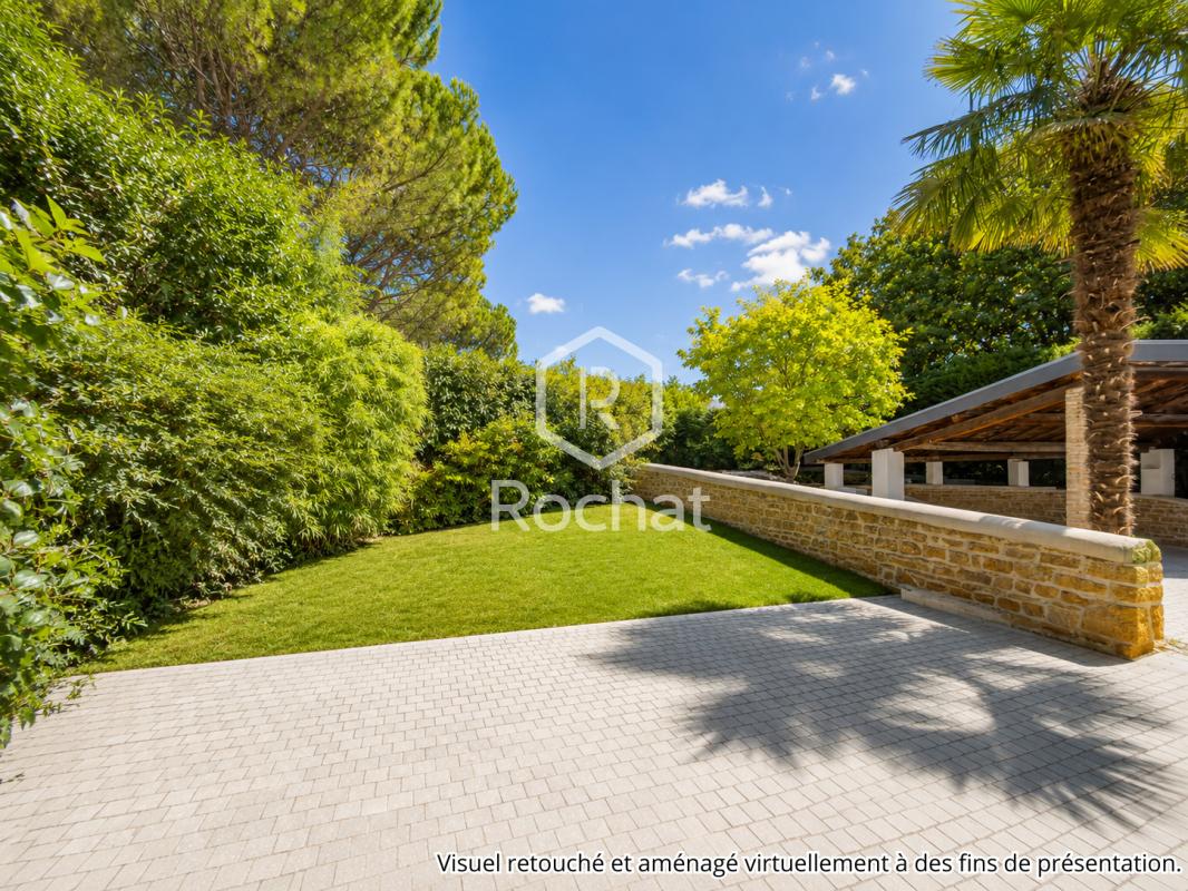Jardin de maison à Curis-au-Mont-d’Or Jardin d'une maison avec pelouse et murs en pierre à Curis-au-Mont-d'Or.