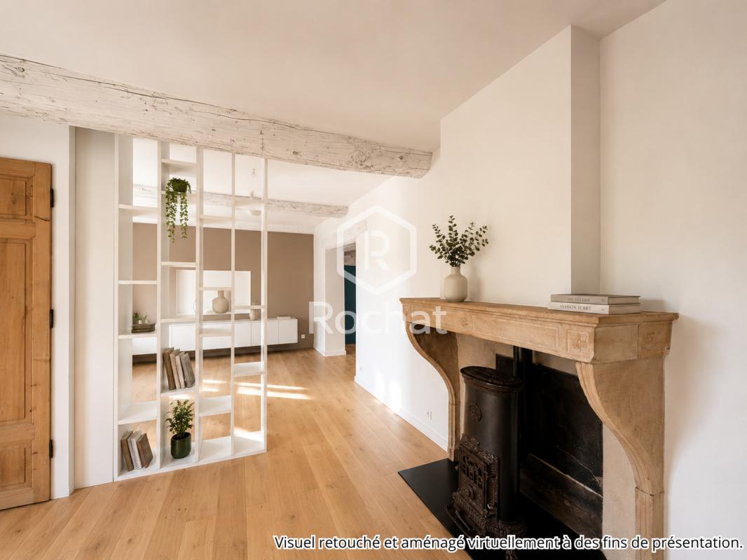 Intérieur d’une maison à Curis-au-Mont-d’Or Intérieur d'une maison rénovée avec cheminée et étagères modernes.