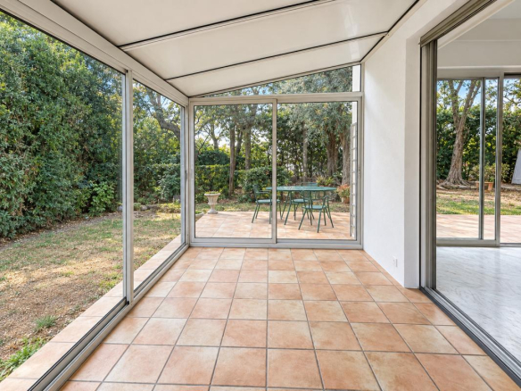 Véranda d'un appartement avec vue sur un jardin arboré à Nice Rimiez.