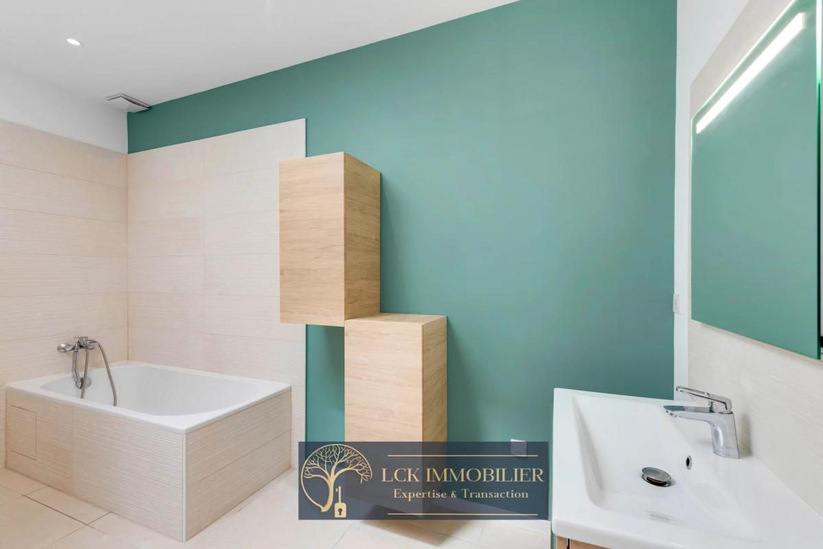 Salle de bain contemporaine Salle de bain moderne avec baignoire et lavabo, murs verts et beige.