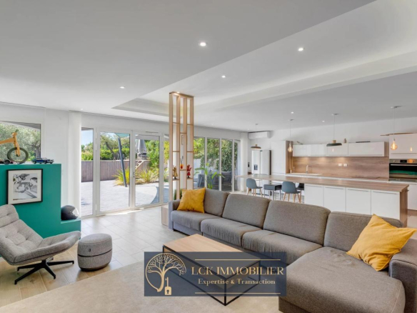 Intérieur d'une villa contemporaine avec salon spacieux et cuisine ouverte, rénovée, à Roquebrune-sur-Argens.
