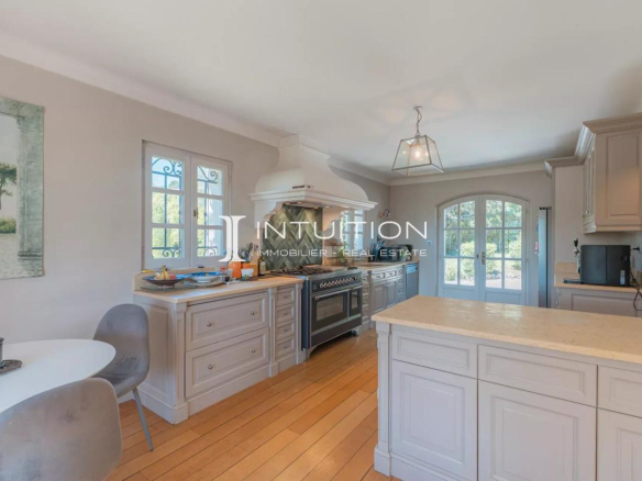 Cuisine moderne et lumineuse d'une villa à Mougins avec îlot central et coin repas.