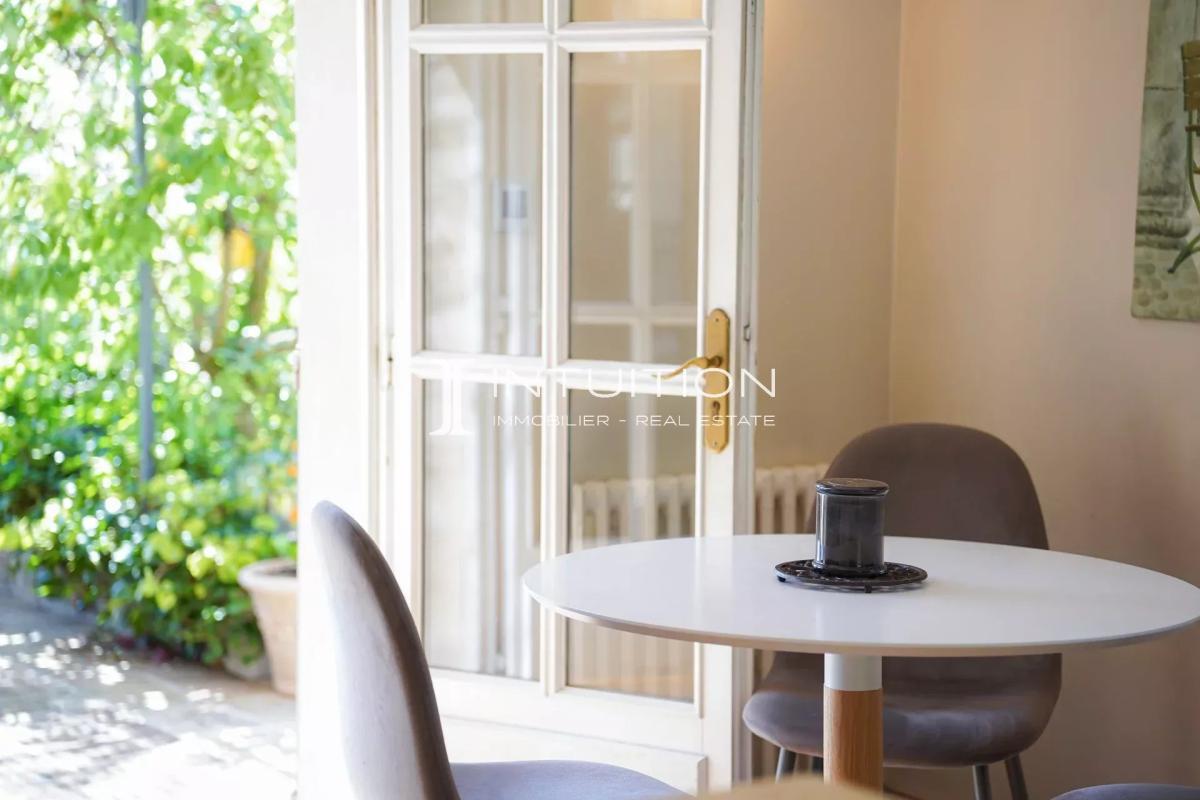 Intérieur de villa à Mougins Intérieur d'une villa à Mougins avec une table et des chaises, lumière naturelle et verdure visible à l'extérieur.