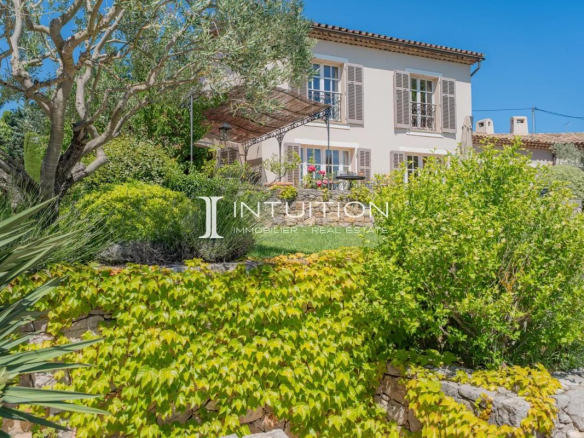 Propriété de prestige à Mougins avec vue sur le village et jardin fleuri.