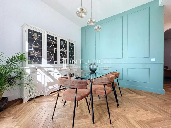 Salle à manger d'un appartement bourgeois à Antibes avec mobilier moderne et murs turquoise.