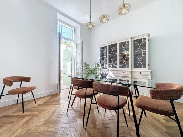 Salle à manger d'un appartement bourgeois à Antibes avec des chaises et une table en verre.