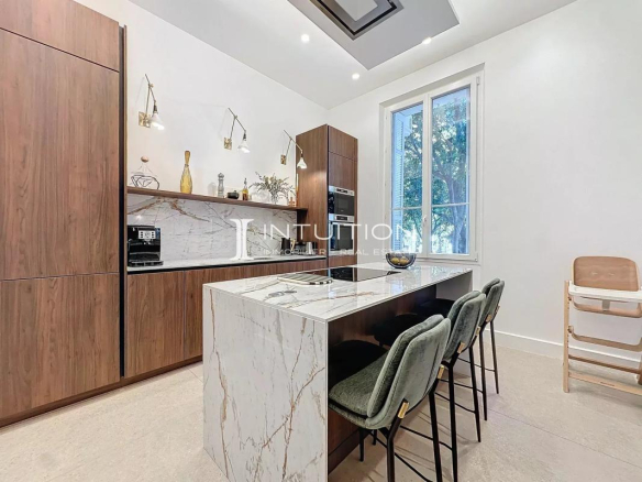 Cuisine moderne avec îlot central et chaises dans un appartement à Antibes.