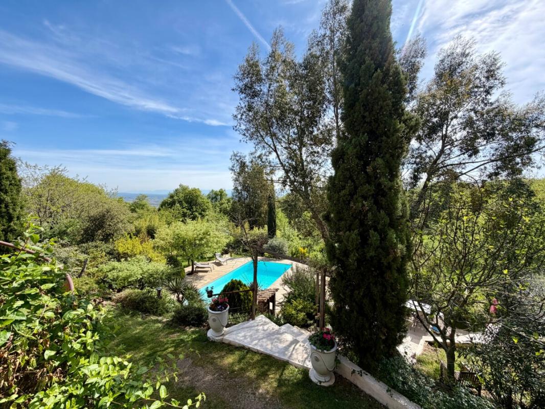 Propriété avec piscine et jardin Vue d'un jardin avec piscine et arbres, propriété en pleine nature.