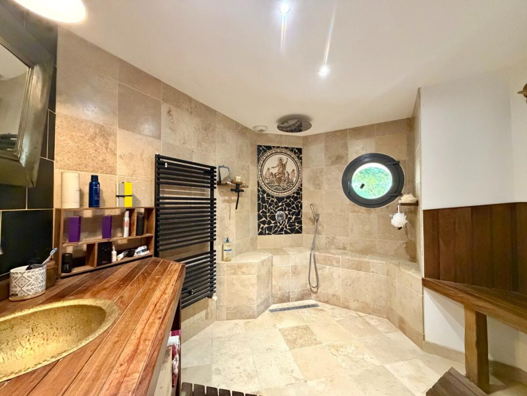 Salle de bains d’une propriété rénovée Salle de bains spacieuse avec douche et lavabo en bois dans une propriété rénovée.