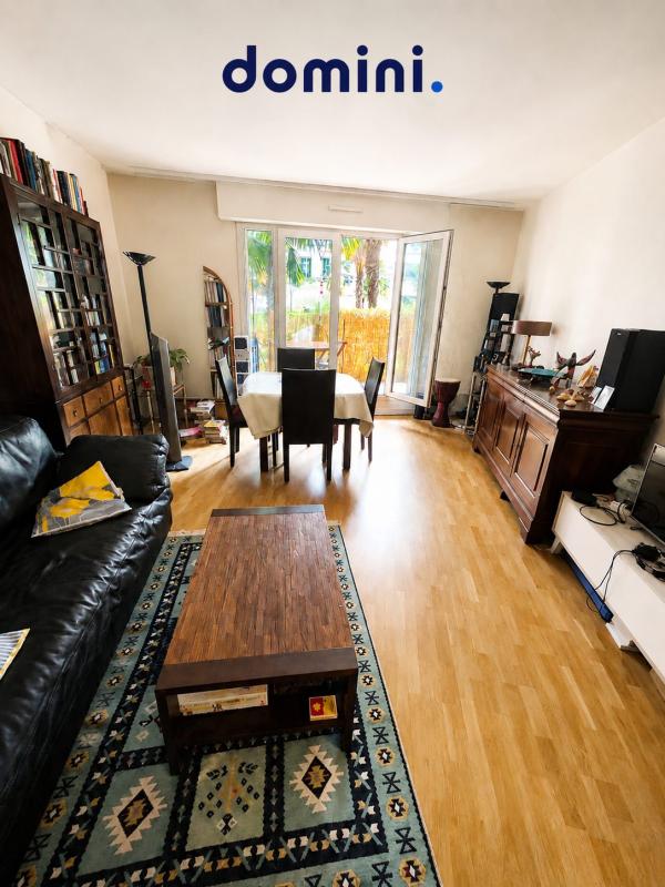 Salon d’un appartement à Montrouge Intérieur d'un appartement à Montrouge avec un salon, une table à manger et un accès à une terrasse.