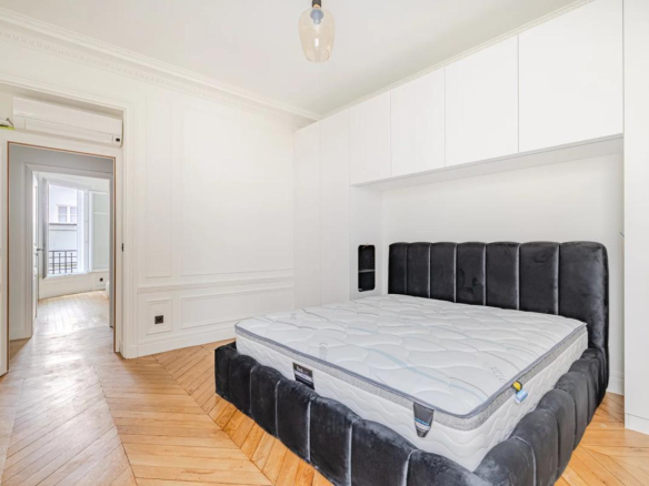 Room in a renovated apartment with built-in bed and wardrobes in Paris 7th arrondissement.