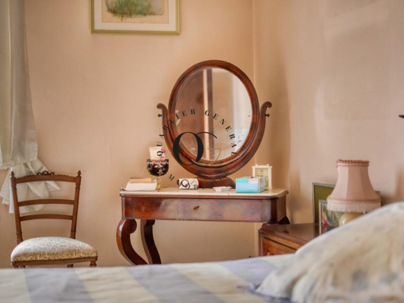 Intérieur d'une chambre avec une coiffeuse en bois et une chaise, ambiance chaleureuse.