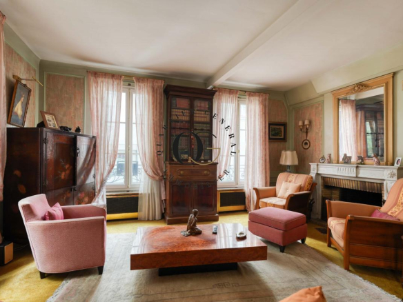 Intérieur d'un salon dans une maison bourgeoise à Saint-Ouen-sur-Seine, avec des meubles vintage et de grandes fenêtres.