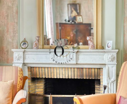 Intérieur d'une maison bourgeoise avec cheminée en marbre et miroir au-dessus.