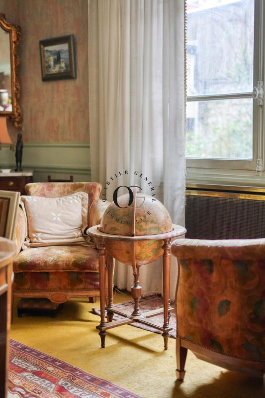 Intérieur d’une maison de maître à Saint-Ouen-sur-Seine Intérieur d'une maison bourgeoise avec un globe terrestre et des canapés anciens.